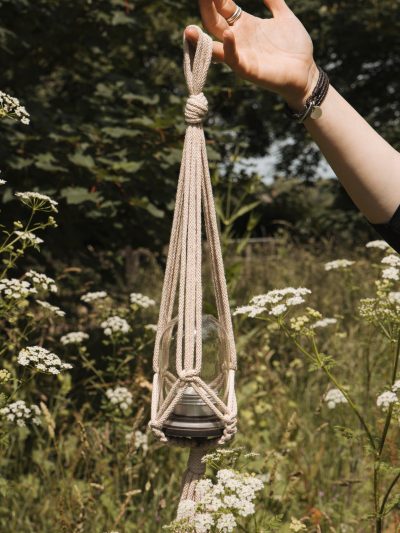 hanging candle holders in front of summer cow parsley