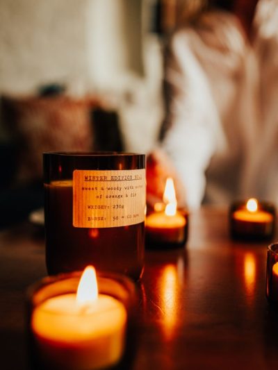 One large winter candle on the table with tea lights lit around it