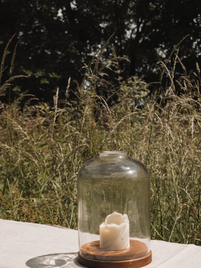 large clear glass candle dome on a table in summer